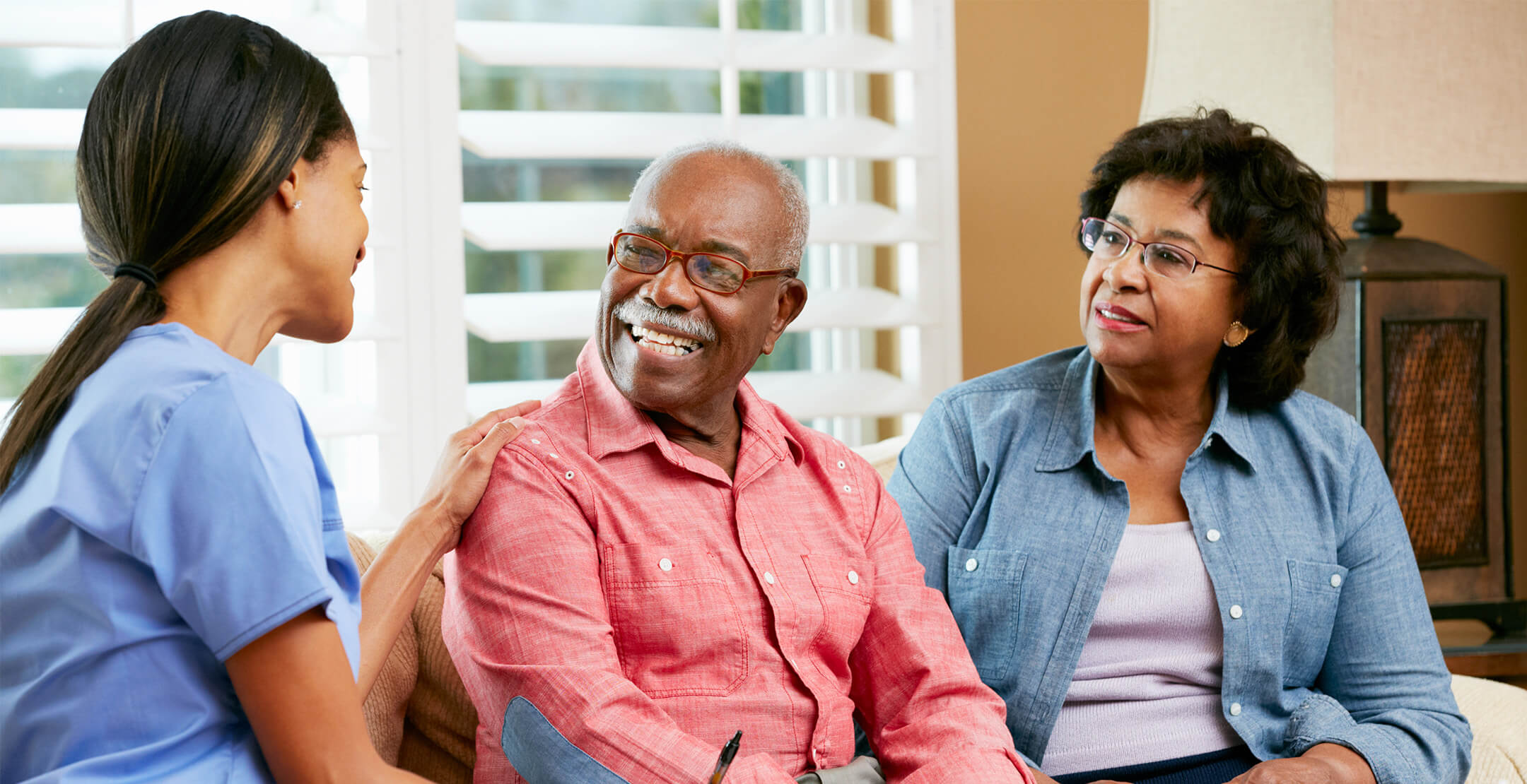 A medical professional speaking to an elder African America couple