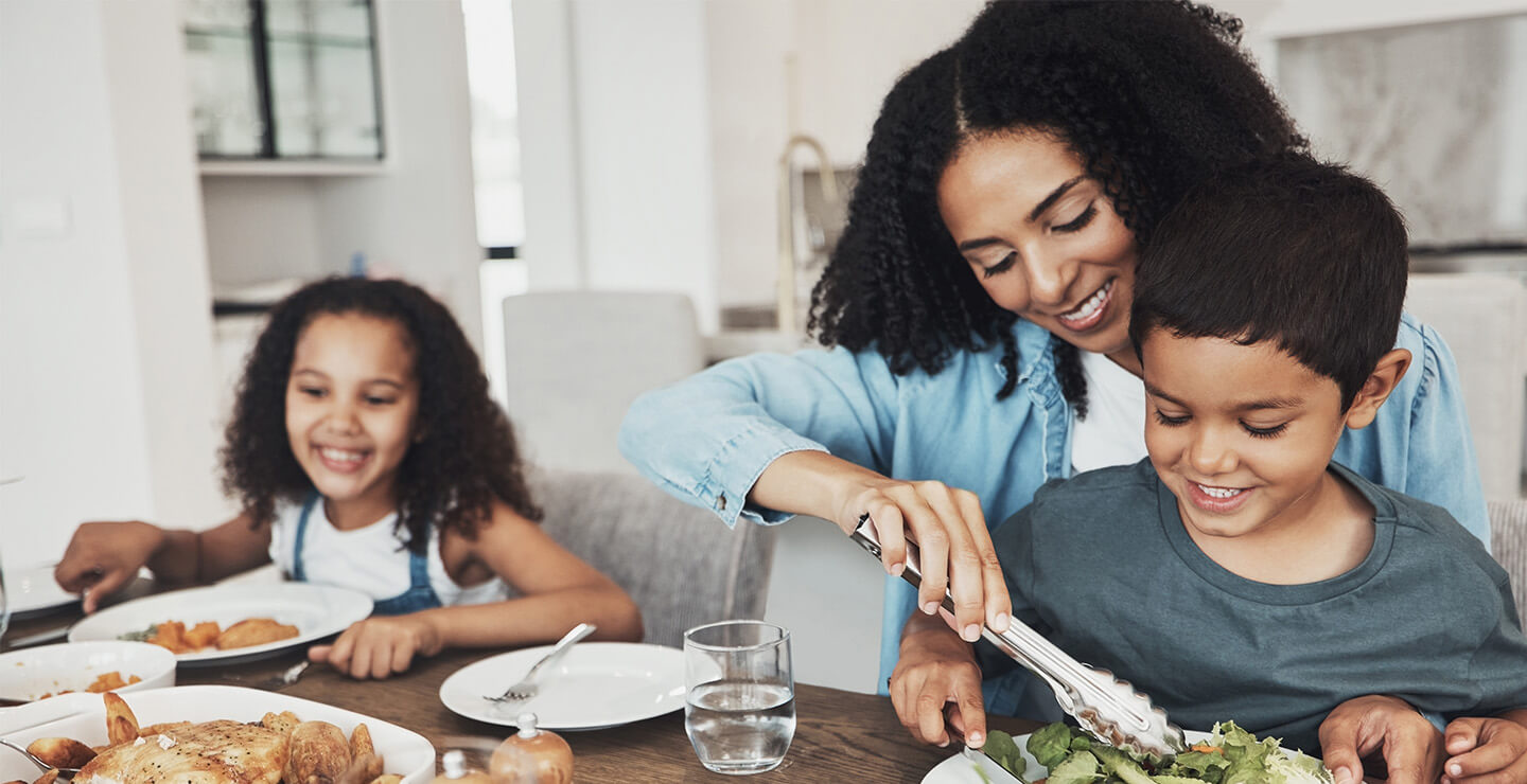 A mother serving a healthy meal to her son and daughter