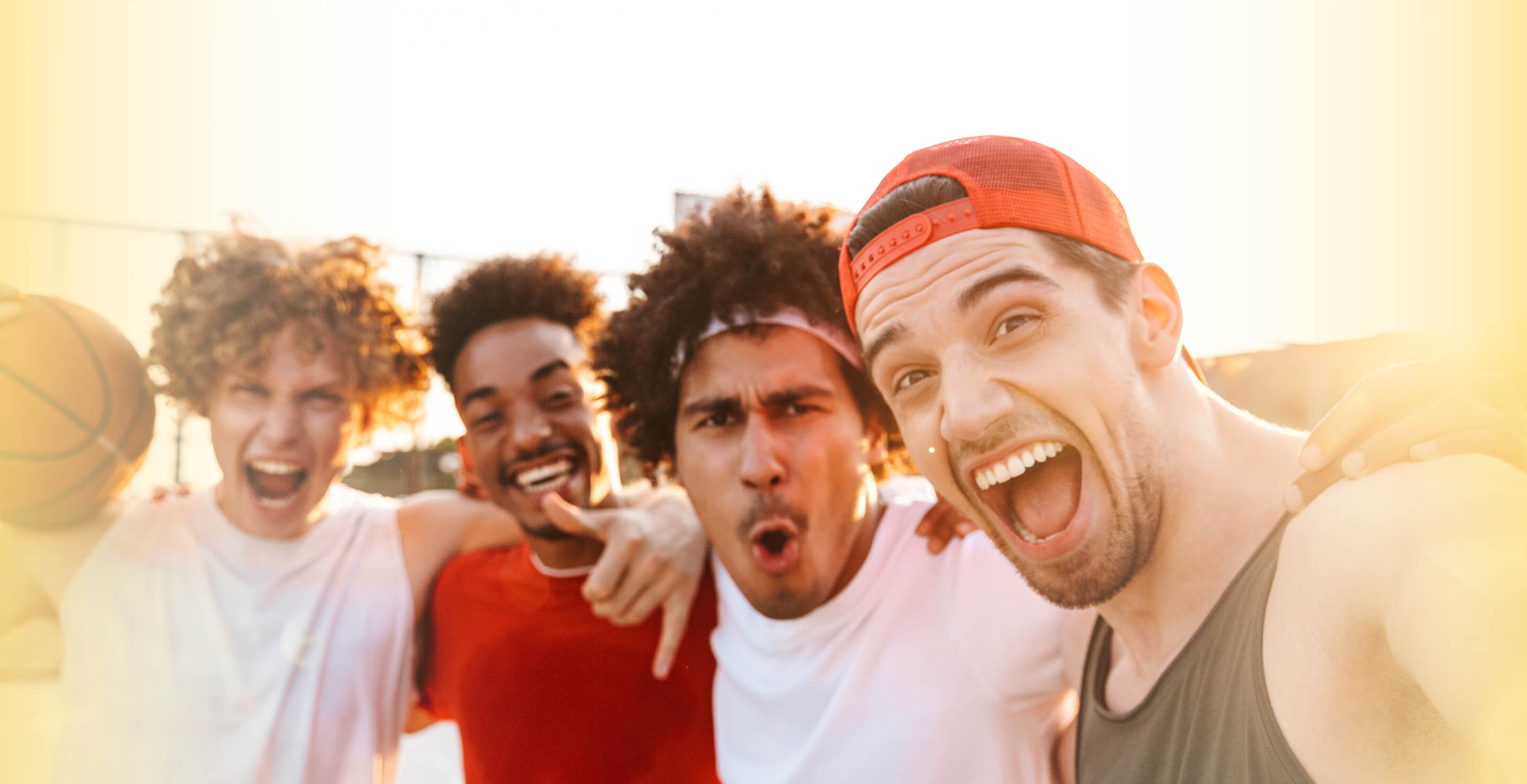 four young men with arms around each other's shoulders
