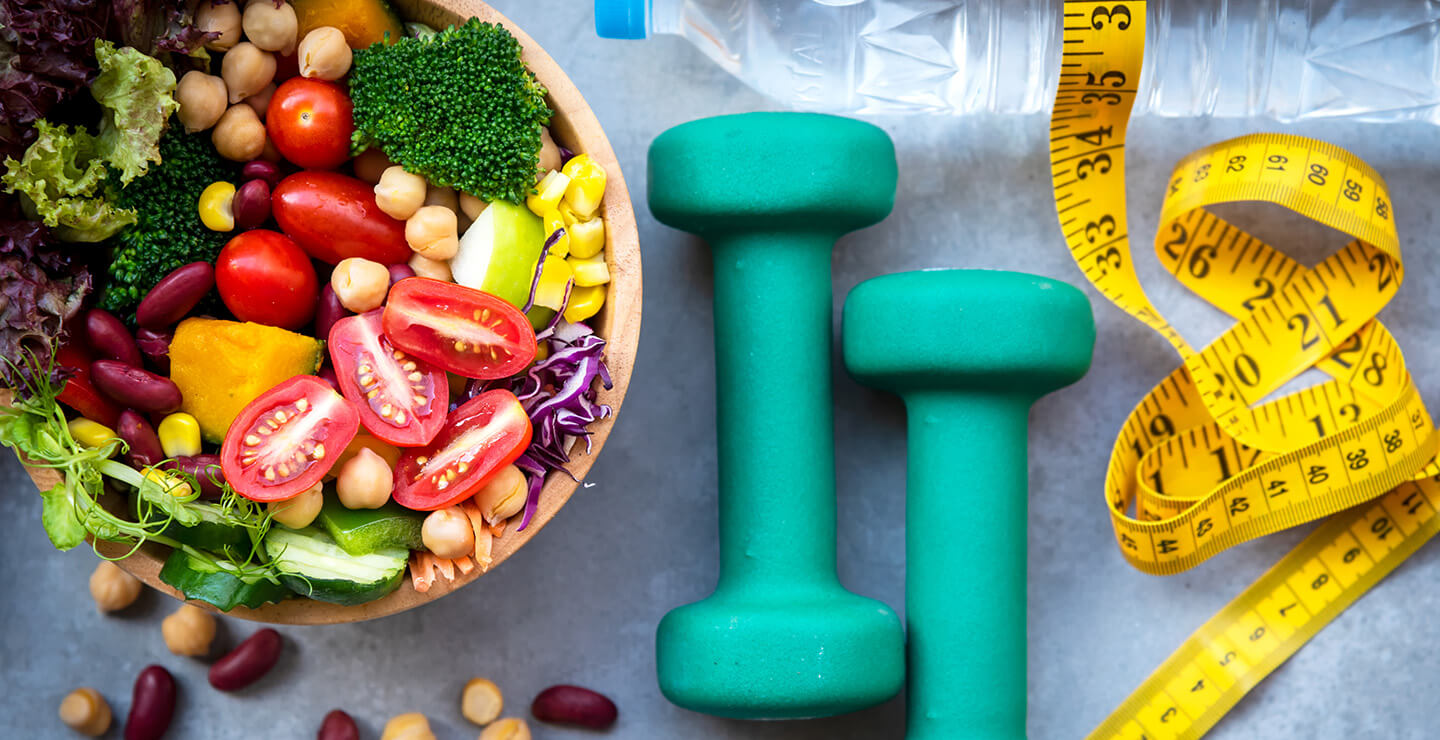 Regulating Weight - Image depicts exercise equipment and a healthy foods.